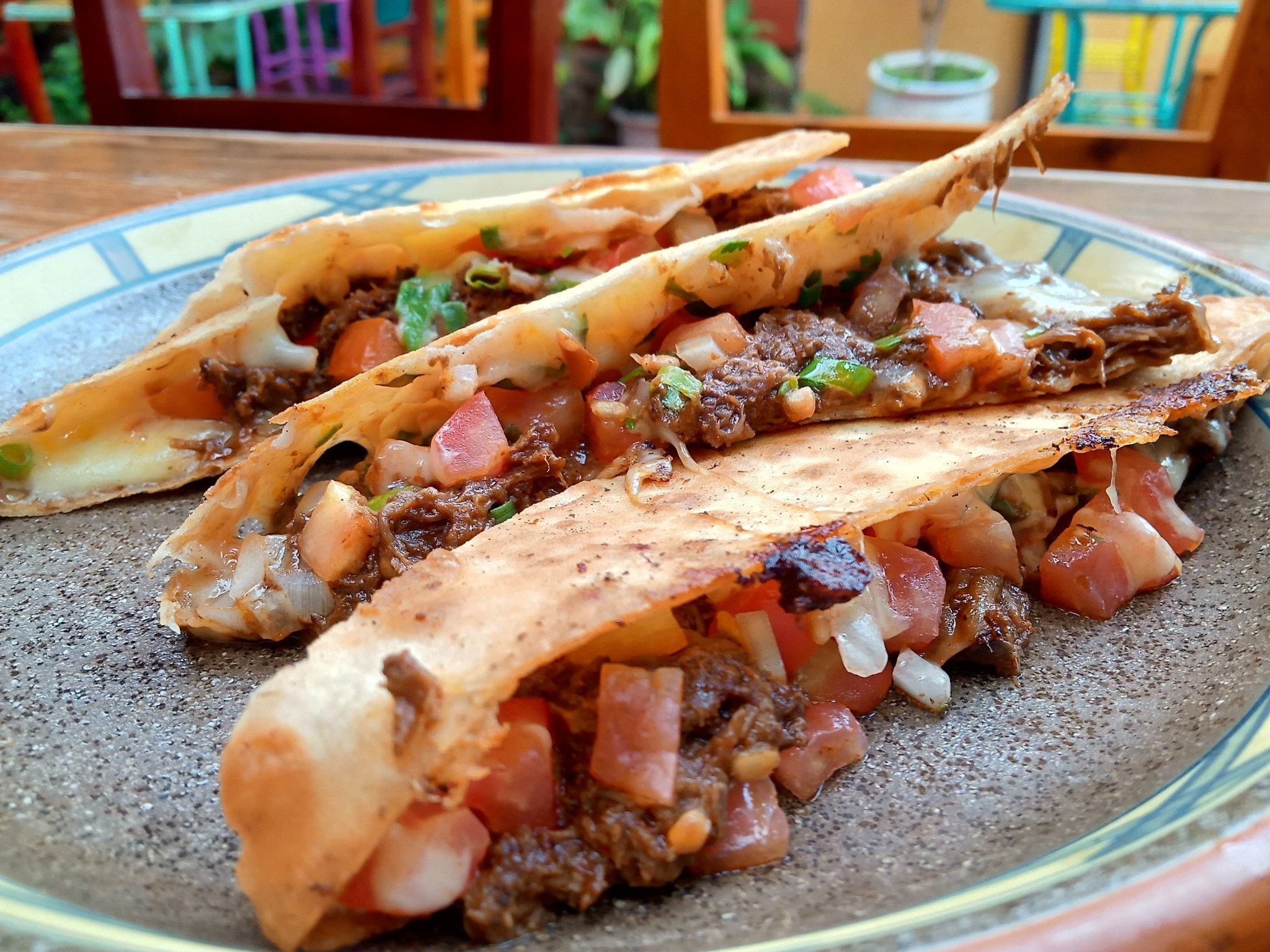 Big handmade flour tortilla chock full of melted cheese and lamb